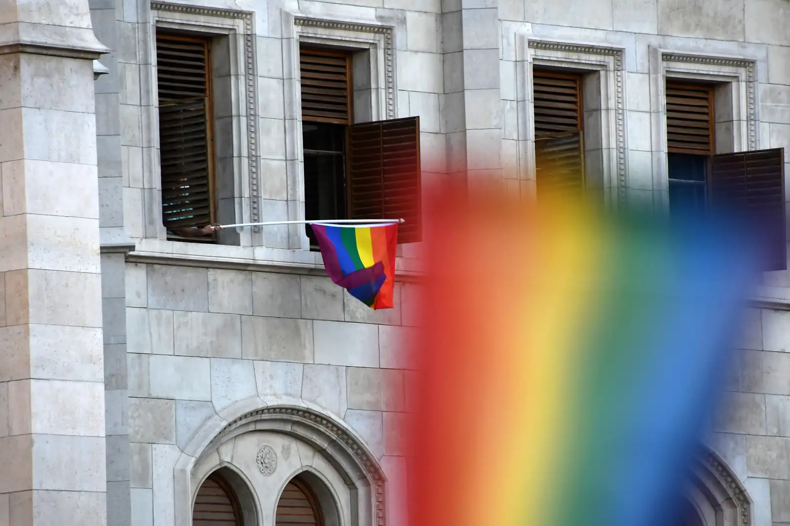 Rainbow flag hung from a window during a 2021 protest against Hungary's anti-LGBT law in Budapest