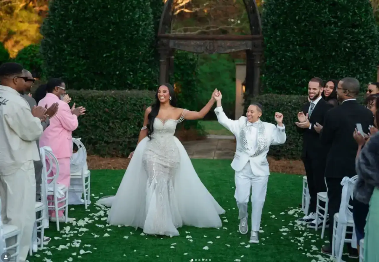 Chantel and Ashley walk down the aisle hand in hand as guests applaud at their wedding